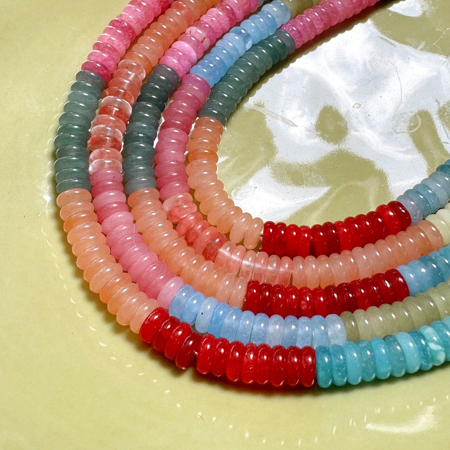 Colorful beaded strands on a light yellow background