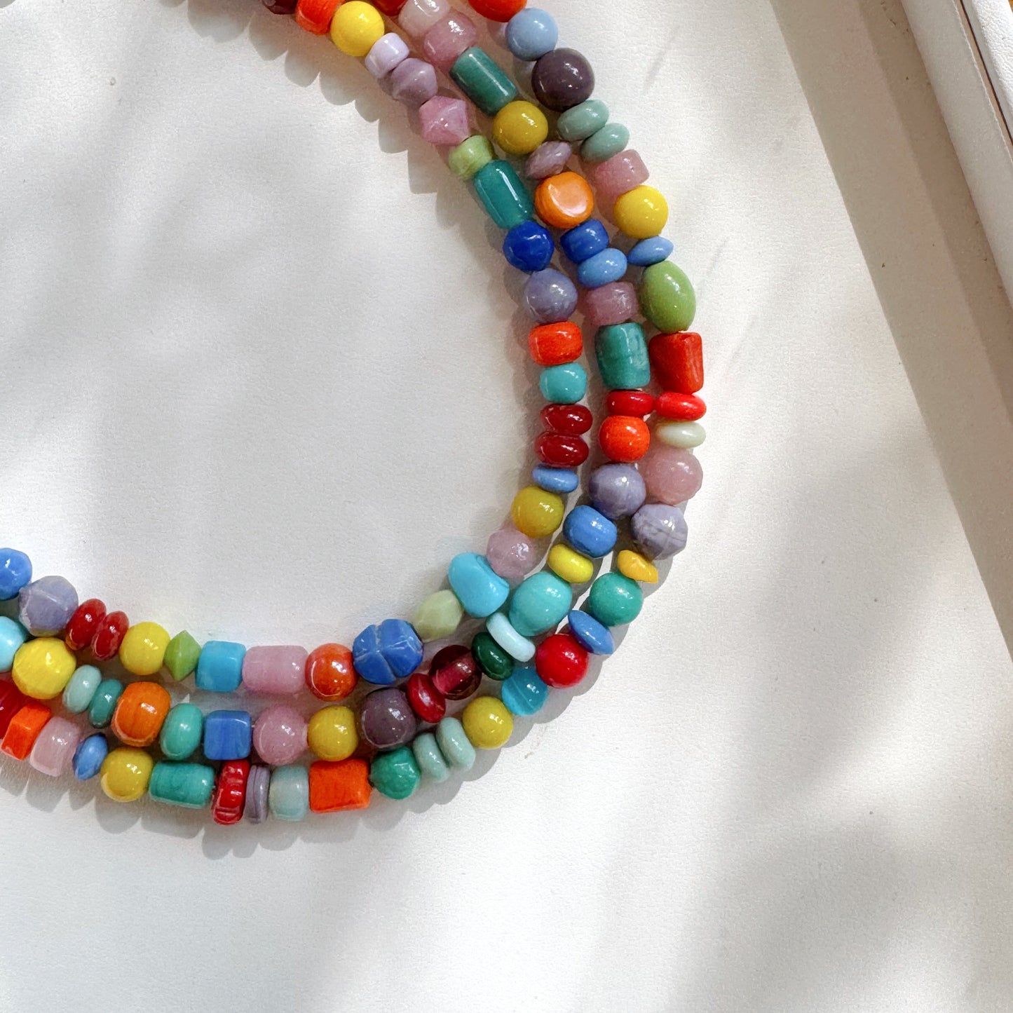 Colorful beaded necklace on a white surface