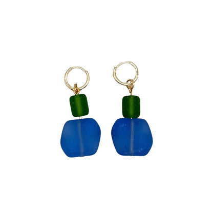 Pair of blue earrings with green beads on a white background