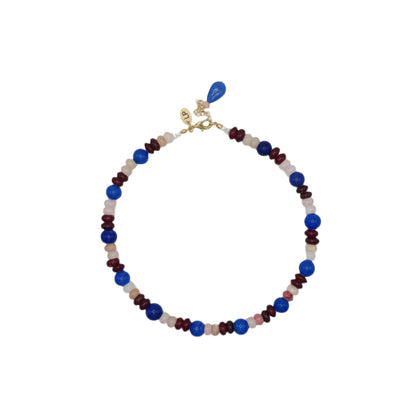 Beaded necklace with blue, red, and gold accents on a white background