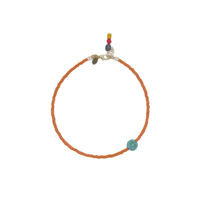 Necklace with orange beads and a turquoise flower  on a white background