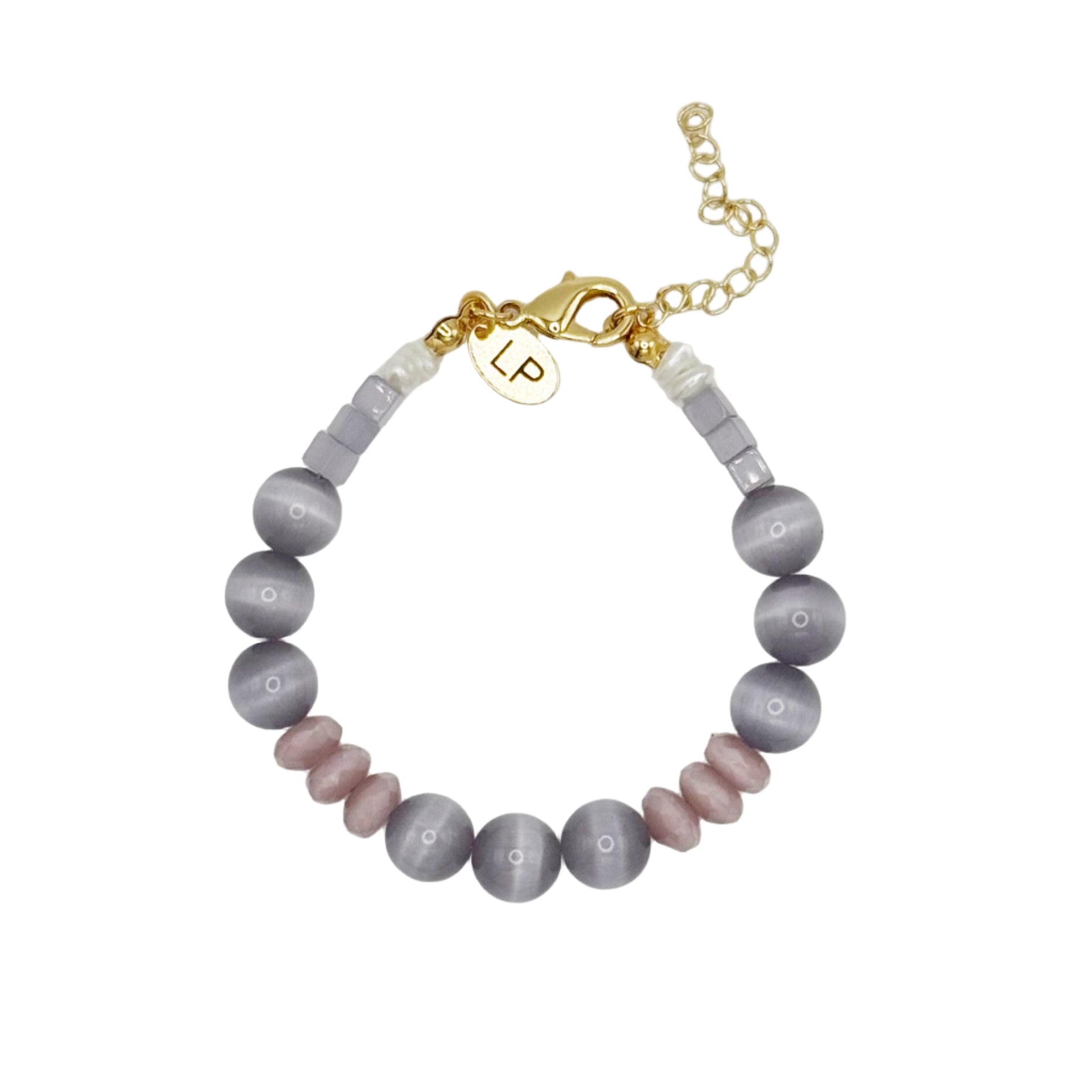Beaded bracelet with gold charm and initials on a light gray background