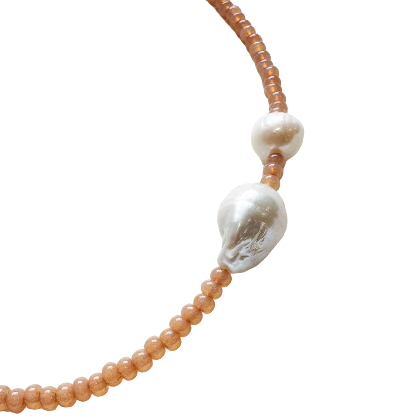 Necklace with peach beads and a silver clasp on a light background