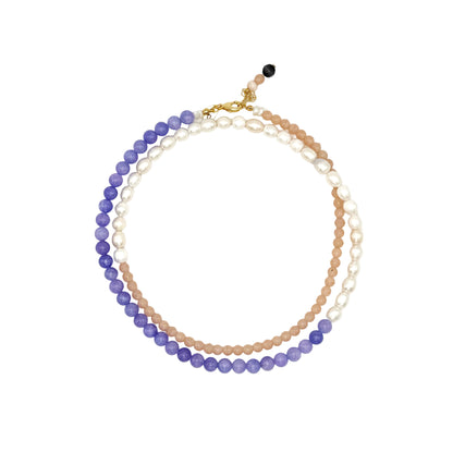 Stack of beaded necklaces on a white background