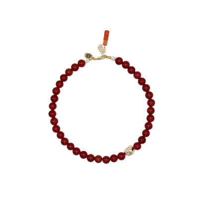 Red beaded necklace with a gold clasp on a white background