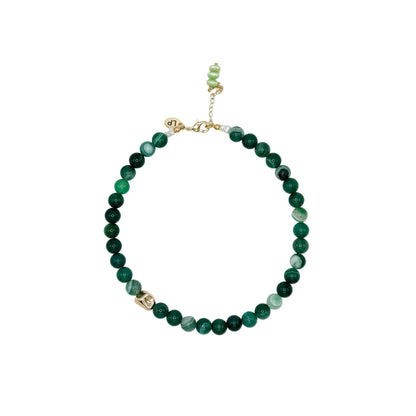 Green beaded necklace on a white background