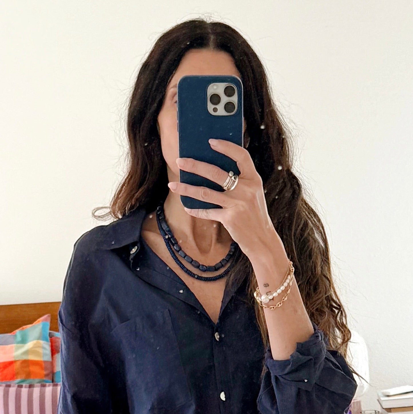 Person wearing a navy blue shirt in a bedroom setting