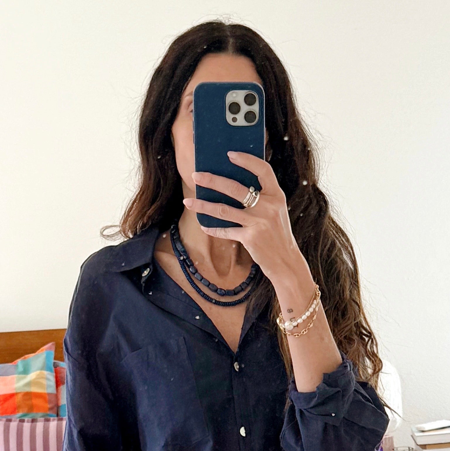 Person wearing a navy blue shirt in a bedroom setting