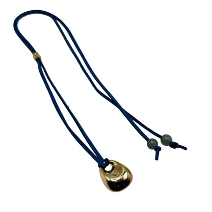 Necklace with a gold pendant on a blue cord against a white background