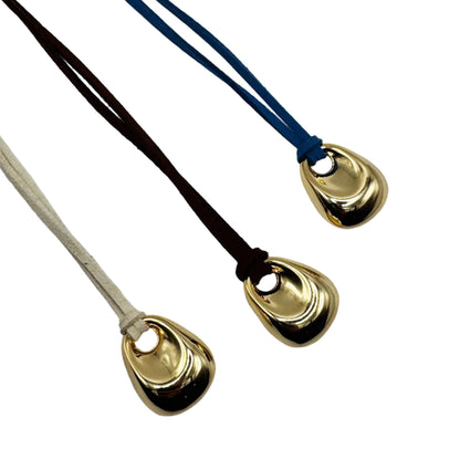 Three gold pendant necklaces on different colored cords against a white background