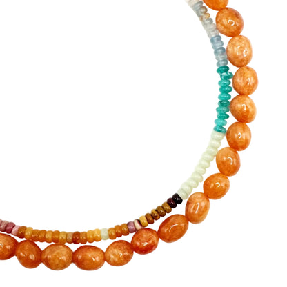 Two beaded necklaces with orange, green, and multicolored beads on a white background
