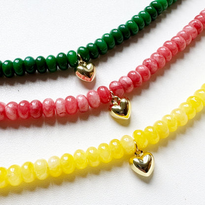 Three beaded necklaces with heart-shaped charms on a white background