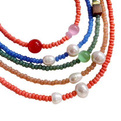 Colorful beaded necklaces on a white surface