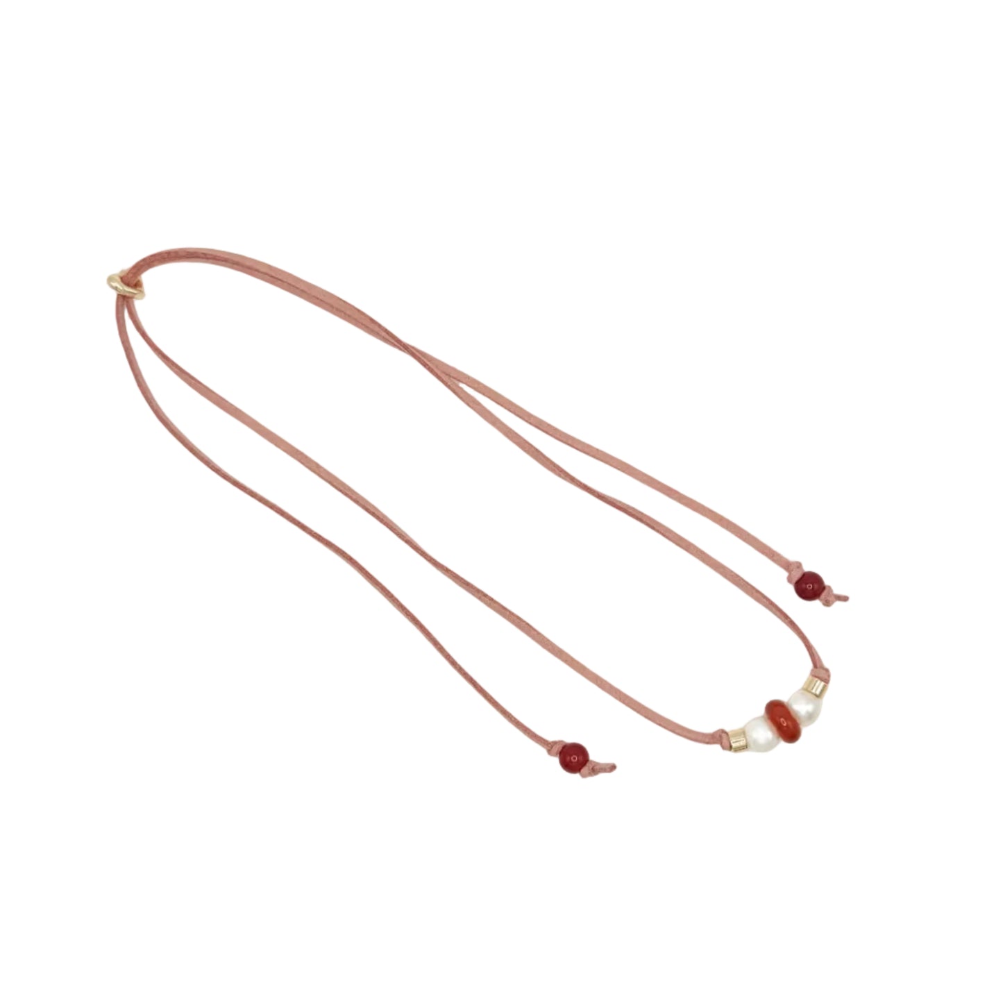 A double-strand cord necklace with small red beads and a few white pearl-like accents, laid flat on a light gray background.