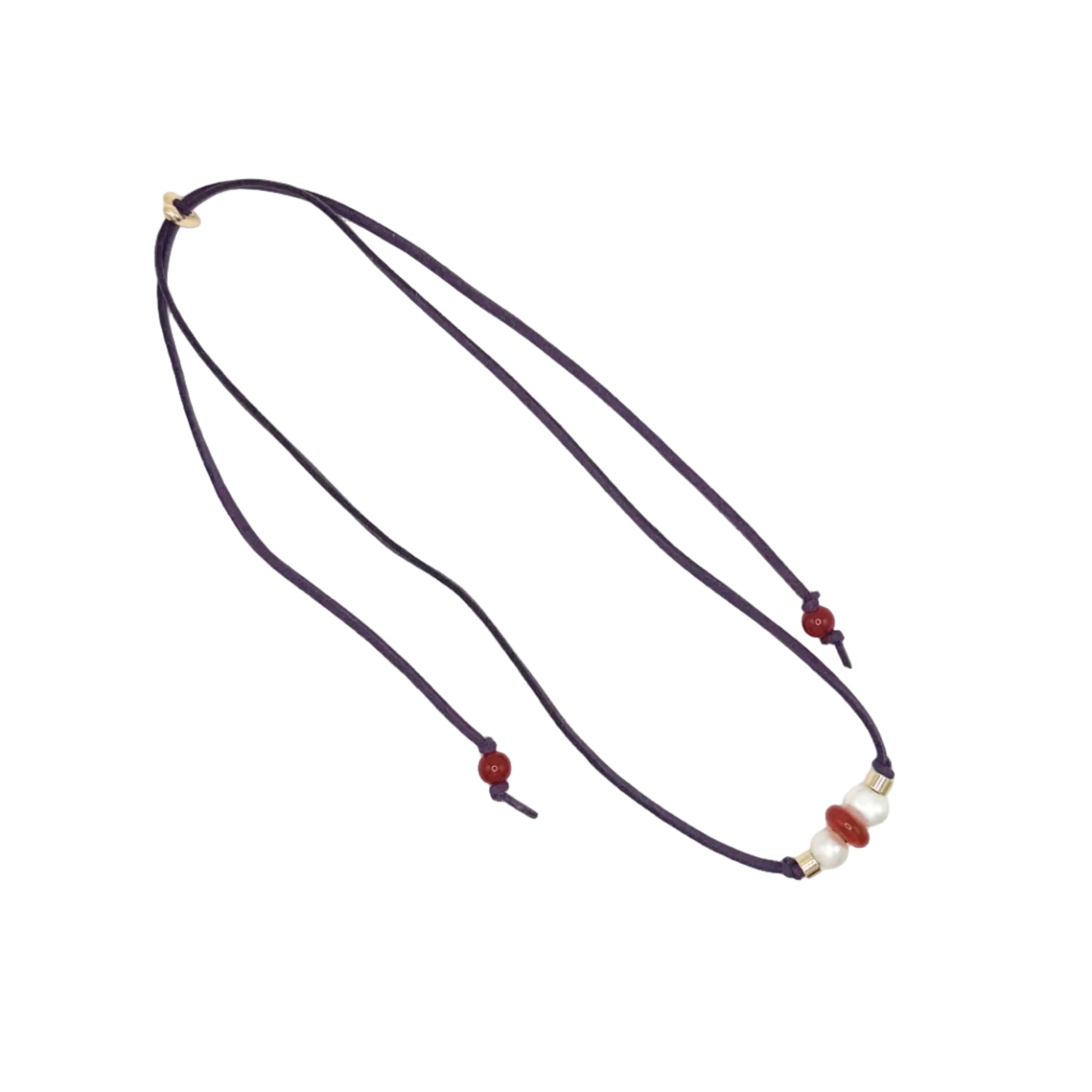 A dark purple cord necklace with small red beads and a white pearl accent, displayed on a clean white background.