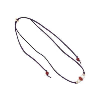 A dark purple cord necklace with small red beads and a white pearl accent, displayed on a clean white background.