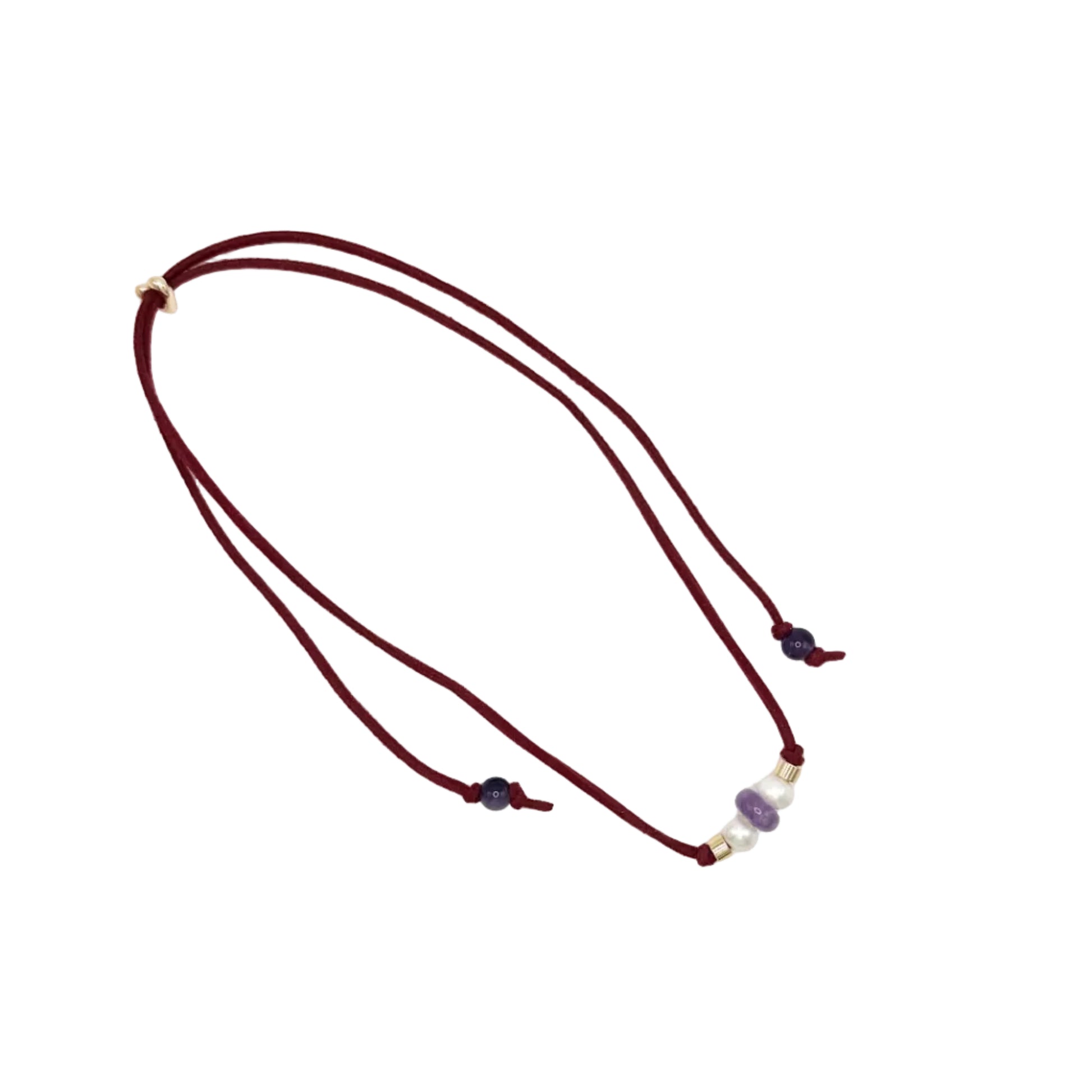 A double-strand cord necklace in deep burgundy, featuring small gold spacer beads and a central cluster of purple and white beads, displayed on a clean white background.