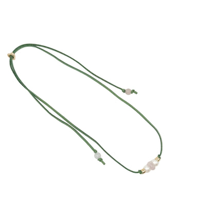 A dark green cord necklace featuring a central cluster of pale pinkish-white beads and small gold spacer rings, displayed on a clean white background.