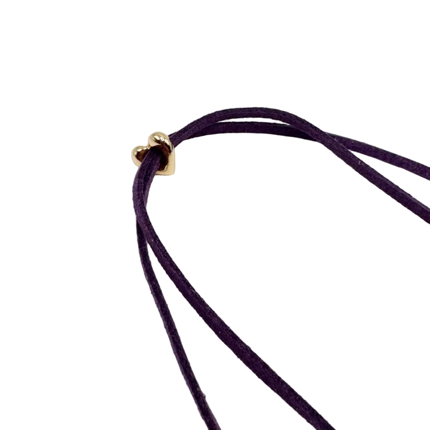 A close-up of a dark purple multi-strand cord necklace with a small gold heart-shaped clasp, set against a plain white background.