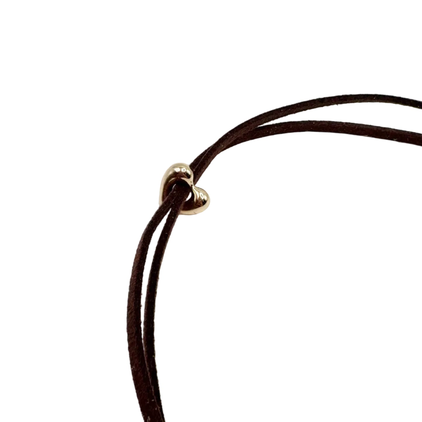 A close-up of a dark brown double-strand cord necklace with a small gold heart-shaped charm, set against a plain white background.