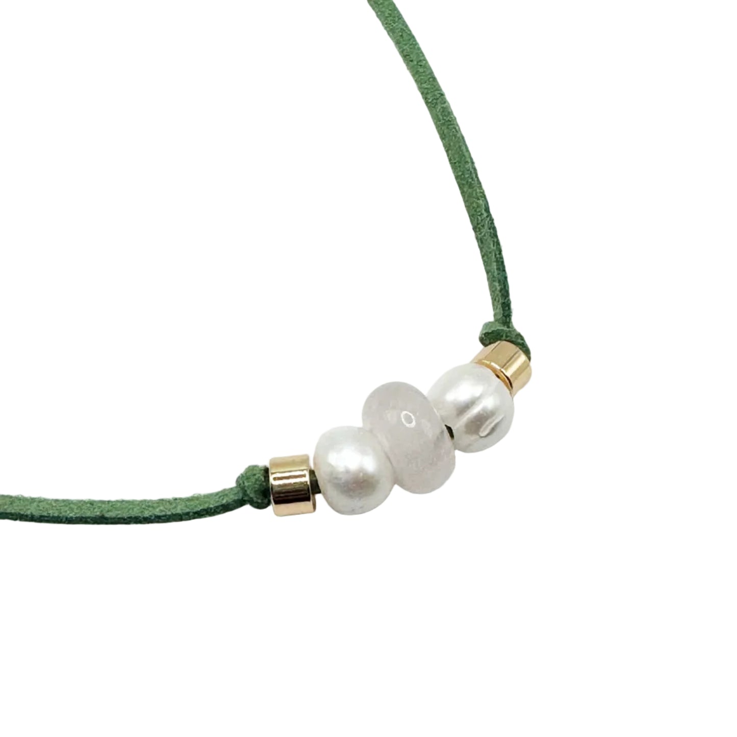A close-up of a green cord necklace featuring three white pearl-like beads and small gold spacer rings, set against a plain white background.