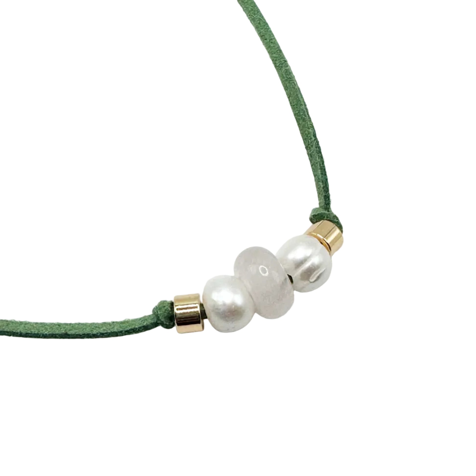 A close-up of a green cord necklace featuring three white pearl-like beads and small gold spacer rings, set against a plain white background.