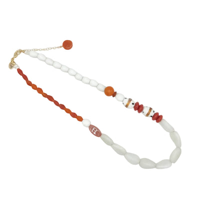 A beaded necklace featuring white oval beads, a red-orange twisted cord, and small striped accent beads, displayed on a clean white background.