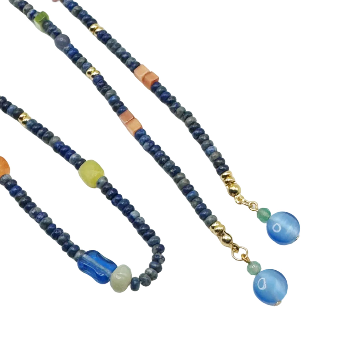 A beaded necklace with dark blue and gray beads, small gold spacer beads, and a drop section featuring a blue cylindrical bead, a light green bead, and two blue oval pendants, displayed on a white background.