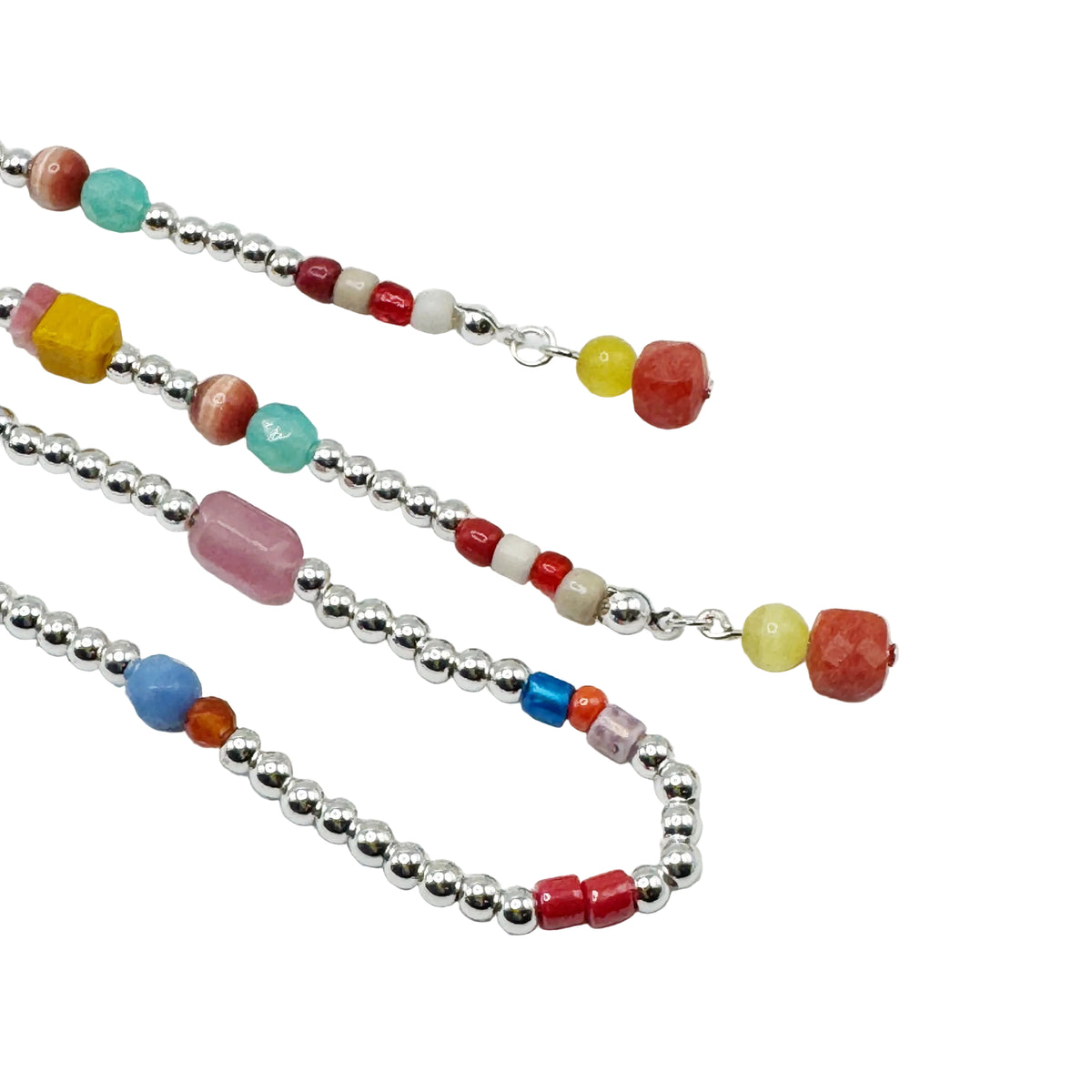 A beaded necklace with silver-toned round beads and colorful accent beads in red, yellow, turquoise, pink, blue, and white, laid out on a plain white background.