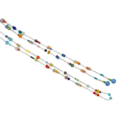 Three long beaded strands or cords laid diagonally on a plain white background. The beads are in many different colors including blue, green, orange, yellow, red, and brown, with some larger polished beads and smaller spacer beads.