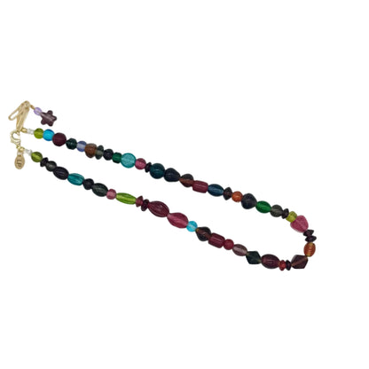 A beaded necklace with faceted glass beads in multiple colors including pink, green, blue, purple, and black, accented with gold-toned spacer beads and a gold clasp, displayed on a plain white background.