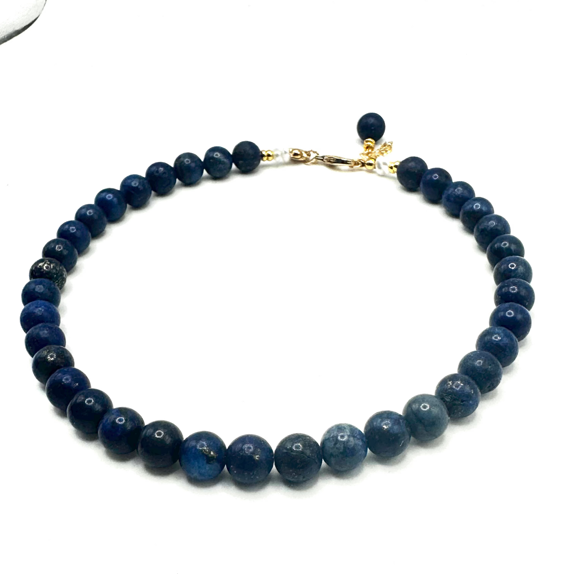 Blue beaded necklace with a gold clasp on a white background