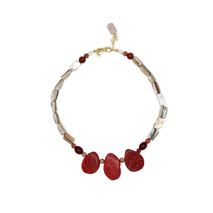 A beaded necklace featuring three large, polished red teardrop-shaped stones at the center, flanked by smaller red beads and irregular metallic silver and gold-toned beads, displayed on a clean white background.