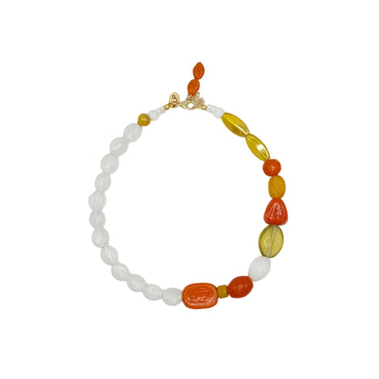A beaded necklace featuring white translucent round beads, polished orange and yellow teardrop-shaped beads, and a small gold clasp, displayed on a clean white background.
