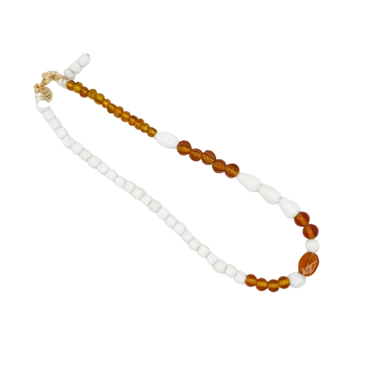 A beaded necklace featuring white square beads, translucent amber brown round beads, and a small gold clasp, displayed on a plain white background.