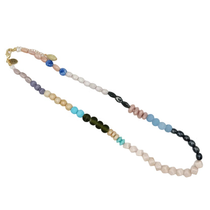 A multi-colored beaded necklace with a gold clasp, featuring segments of pastel pink, light blue, dark green, turquoise, purple, and black beads on a white background.